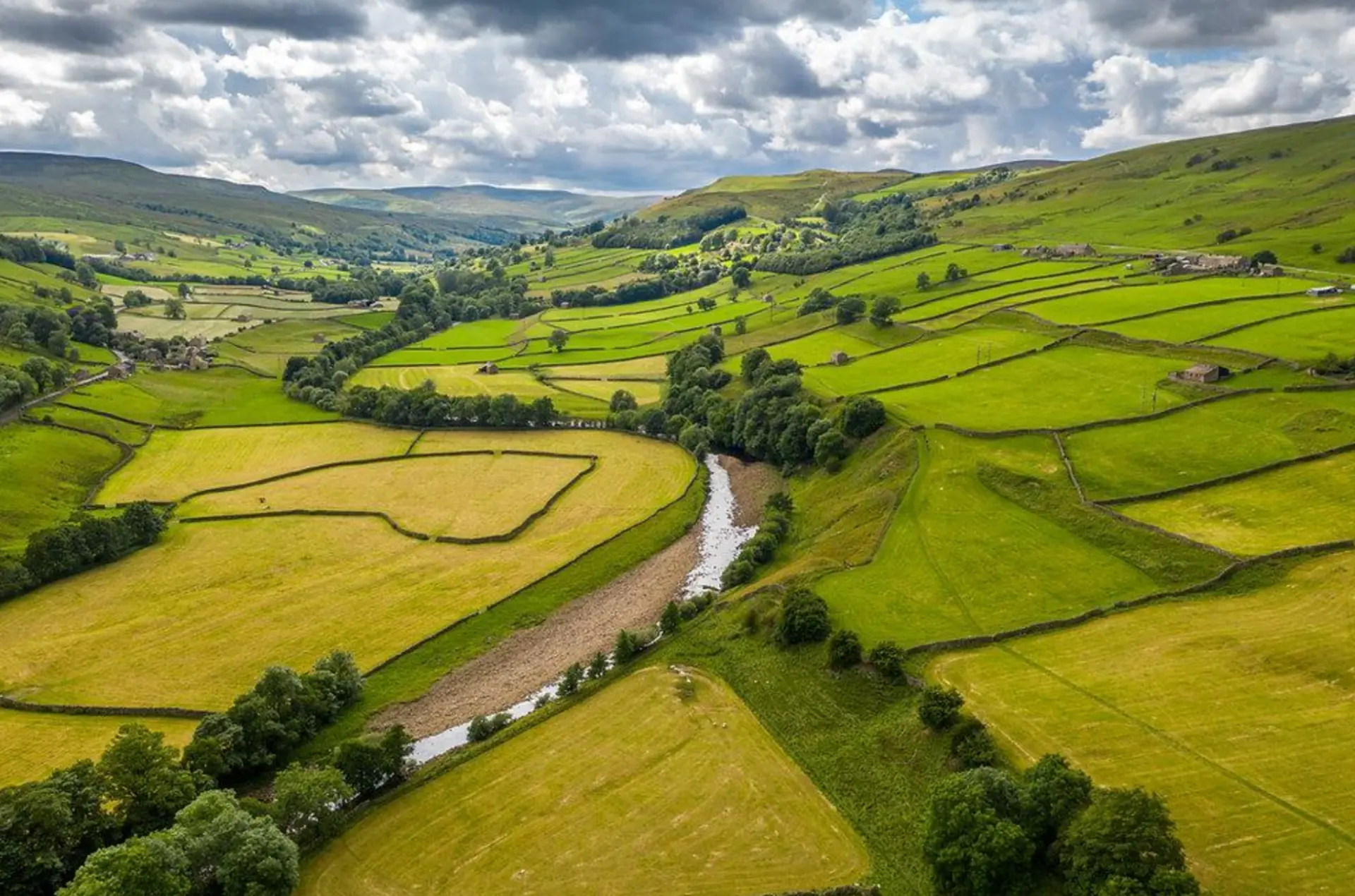 River winding through green agricultural fields and a rural valley